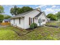 Another side view of the house with white siding and yard with green space at 417 S Broad St, Gastonia, NC 28052