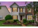 Two-story home with red shutters and inviting front yard, captured during a colorful sunset at 4213 Coulter Xing, Charlotte, NC 28213