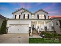 Charming two-story home featuring a welcoming front porch, attached two-car garage, and well-maintained landscaping at 4842 Durneigh Dr, Kannapolis, NC 28081