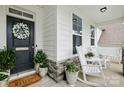 Inviting front porch featuring rocking chairs, decorative wreath, and charming decor at 4842 Durneigh Dr, Kannapolis, NC 28081