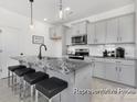 Modern kitchen with gray cabinets, stainless steel appliances, and a marble-topped island with seating at 499 Switch St # 128, York, SC 29745