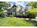 A charming two-story home with dormer windows, black shutters, manicured landscaping, and a well-maintained lawn at 503 New Castle Ne Ct, Concord, NC 28025