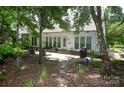 Exterior view of the home with a patio area, mature trees and a stepping stone path at 6009 Swanston Dr, Charlotte, NC 28269