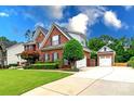 View of a two-story brick home, detached garage, and long driveway at 6202 Pumpernickel Ln, Wesley Chapel, NC 28110