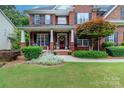 Charming brick home with a covered front porch and mature shrubbery at 6202 Pumpernickel Ln, Wesley Chapel, NC 28110