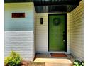 Close-up of a vibrant green front door with brick and siding at 7228 Rollingridge Dr, Charlotte, NC 28211