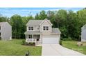 Charming two-story home features a covered porch, attached two car garage, and well-manicured lawn at 7308 Rothmore St, Charlotte, NC 28215