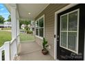 View of the covered front porch with a potted plant, and a view of the neighborhood at 7308 Rothmore St, Charlotte, NC 28215