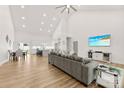 Open-concept living room features a vaulted ceiling, wood floors, and a seamless flow to the modern kitchen at 7683 Sarah Dr, Denver, NC 28037