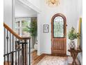Inviting foyer with hardwood floors, an arched front door with iron detailing, and a decorative chandelier at 7738 Burning Ridge Dr, Stanley, NC 28164