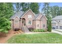Elegant brick home boasts lush landscaping, mature trees, and inviting curb appeal at 7738 Burning Ridge Dr, Stanley, NC 28164