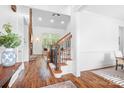 Open-concept living room boasts hardwood floors, a stone fireplace, and abundant natural light from large windows at 7738 Burning Ridge Dr, Stanley, NC 28164