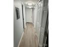Hallway with wood-look flooring and crisp white trim; multiple doors for storage at 8029 Cedar Glen Dr, Charlotte, NC 28212