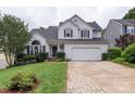 Daytime view of a charming two-story home featuring a manicured front lawn, inviting entrance, and attached two-car garage at 8605 Tamarron Dr, Charlotte, NC 28277