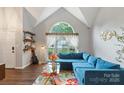 Bright living room with vaulted ceiling, oversized window, hardwood floors, and a comfortable blue sectional sofa at 8605 Tamarron Dr, Charlotte, NC 28277
