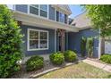 Inviting entrance with decorative shrubs, wood pillars and neutral exterior at 9230 Loch Glen Way, Charlotte, NC 28278