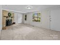 Bright living room featuring a brick fireplace, neutral carpeting, and natural light from large windows at 94 Sumner Nw Ave, Concord, NC 28027