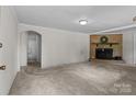 Spacious living room with neutral carpeting, a brick fireplace, and access to other rooms at 94 Sumner Nw Ave, Concord, NC 28027