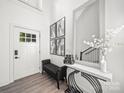 Bright foyer with wood floor, bench, decor table, and front door at 9712 Worley Dr, Charlotte, NC 28215