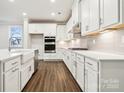 Modern kitchen boasts white cabinets, stainless steel appliances, and a farmhouse sink at 9924 Manor Vista Trl, Kannapolis, NC 28027