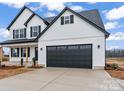 Modern farmhouse style home with a two-car garage, white siding and black trim on a sunny day at Lot 100 Coppergate Dr, Salisbury, NC 28147