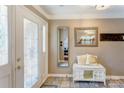 Bright entry featuring a white door with decorative glass, tiled floors and a bench with mirrors at 1066 Iveywood Nw Pl, Concord, NC 28027