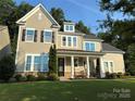 Charming two-story home with a covered front porch, manicured lawn, and inviting curb appeal at 11216 Preservation Ln, Charlotte, NC 28278