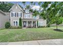 Charming home with meticulously maintained lawn, covered front porch, neutral siding, and beautifully landscaped flower beds at 11216 Preservation Ln, Charlotte, NC 28278