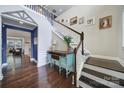 Elegant foyer showcases hardwood floors, a wooden staircase, designer console table, and stylish blue accent wall at 11216 Preservation Ln, Charlotte, NC 28278