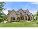 Stately two-story home with brick exterior, lush landscaping, and well-maintained lawn at 1152 Grand Oak Dr, Waxhaw, NC 28173