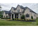 Desirable home with a manicured lawn, featuring a classic brick facade, framed by well-maintained landscaping at 1152 Grand Oak Dr, Waxhaw, NC 28173