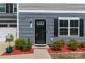 Charming front entrance with manicured landscaping and a black front door at 116 Crownpiece St, Troutman, NC 28166