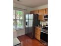 Galley kitchen with a stainless steel refrigerator, stainless range, and view of the yard at 12238 Paperbark Cir, Charlotte, NC 28277