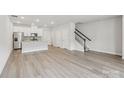 Open-concept living space featuring hardwood floors, a modern kitchen, and staircase at 124 Utility Ln # B, Mooresville, NC 28117
