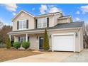 Charming two-story home with a well-maintained lawn, attractive landscaping, and an attached garage at 130 Valley Glen Dr, Troutman, NC 28166