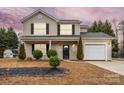 Charming two-story home featuring a manicured front yard and attached one car garage at 130 Valley Glen Dr, Troutman, NC 28166