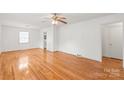 Bright living room with gleaming hardwood floors and a large window letting in natural light at 1320 Hartford Ave, Charlotte, NC 28209