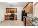 Bright eat-in kitchen showcases stainless steel sink, granite countertops, tiled backsplash, and black appliances at 14853 Santa Lucia Dr, Charlotte, NC 28277
