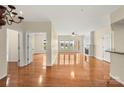Expansive living room features hardwood floors, neutral paint, fireplace, and multiple windows for bright natural light at 14853 Santa Lucia Dr, Charlotte, NC 28277