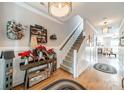 Warm and inviting foyer featuring hardwood floors, elegant decor, and a staircase leading to the upper level of the home at 16425 Spruell St, Huntersville, NC 28078