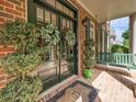 Charming front porch with double doors, potted plants, and a porch swing at 18419 Dembridge Dr, Davidson, NC 28036