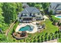 Aerial view of a private backyard oasis with pool, spa, outdoor kitchen, and manicured landscaping at 2004 Garden View Ln, Weddington, NC 28104