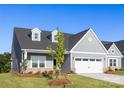 Charming single-story home featuring light blue siding, dormer windows, green front door and a two-car garage at 219 Tillery Ln # 755, Mount Gilead, NC 27306