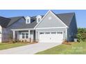 Charming single-story home featuring light blue siding, dormer windows, green front door and a two-car garage at 219 Tillery Ln # 755, Mount Gilead, NC 27306