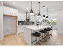 Modern kitchen features a large island with seating, white cabinets, stainless steel appliances, and stylish pendant lighting at 219 Tillery Ln # 755, Mount Gilead, NC 27306