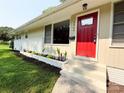 Close up of a single-story home with a red front door and lovely landscape at 2469 Elkwood Cir, Charlotte, NC 28205