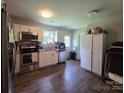 This kitchen has white cabinets, stainless steel appliances and luxury vinyl plank flooring at 290 Greentree Dr, Rock Hill, SC 29730