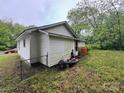 Backyard view showcasing the home's vinyl siding and grassy yard at 415 Orange St, Shelby, NC 28150