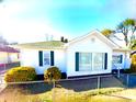 Inviting single-story home with a classic white exterior, green shutters, and neat landscaping at 447 17Th St, Cramerton, NC 28032
