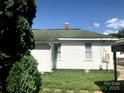 Back exterior view of a home with white siding and trim, with a green roof and well-maintained backyard at 447 17Th St, Cramerton, NC 28032